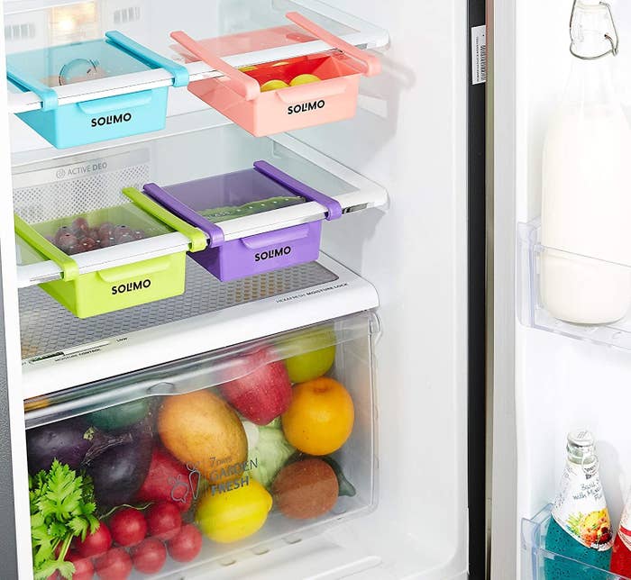 Fridge organisers attached to the shelves in a fridge with food items in them