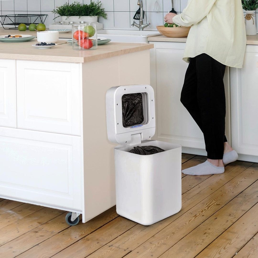 The open trash can next to a kitchen island