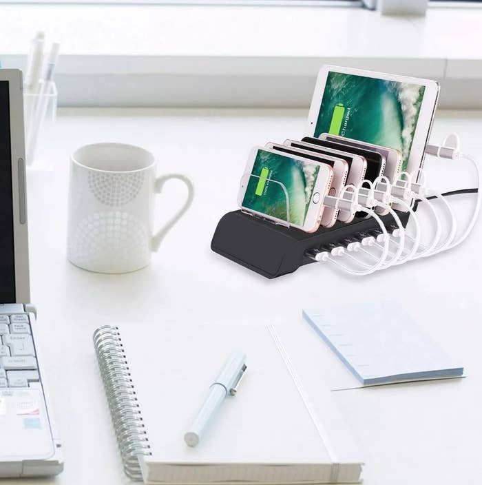 A 6-port, USB charging station filled with iPhones and tablets on an office desk
