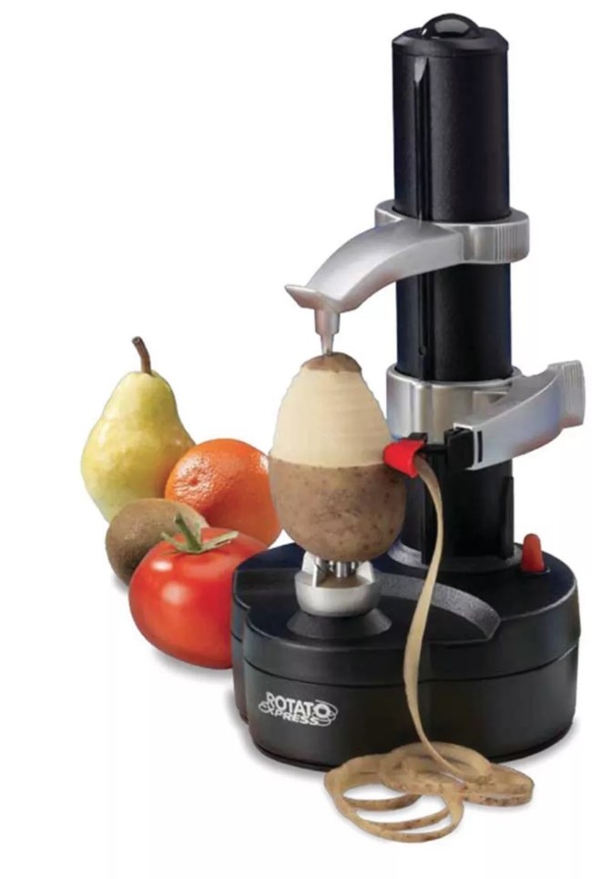 A black, electric fruit and vegetable peeler being used to peel a pear