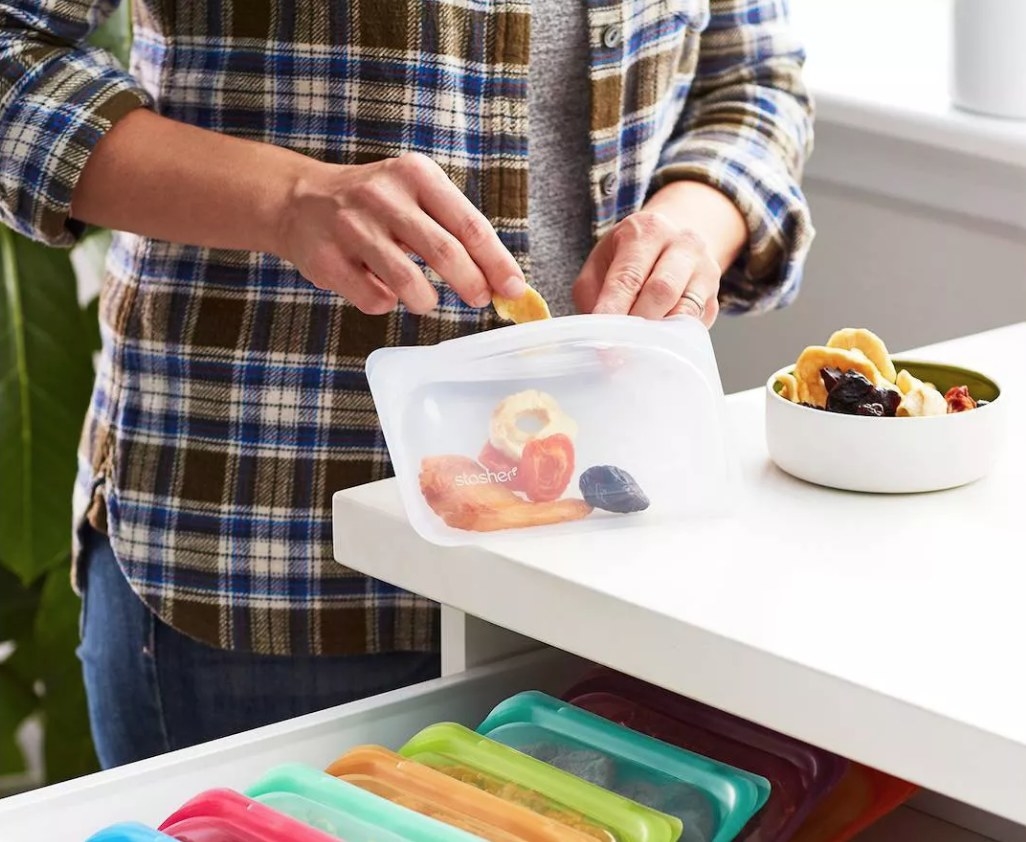 A model placing dried fruit into a clear, reusable snack bag