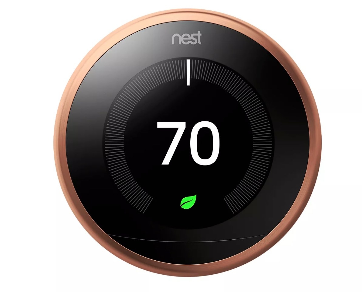 A copper Google Nest thermostat indicating a temperature of 70 degrees with the Google Nest Leaf lit up to indicate that it is an energy-saving temperature