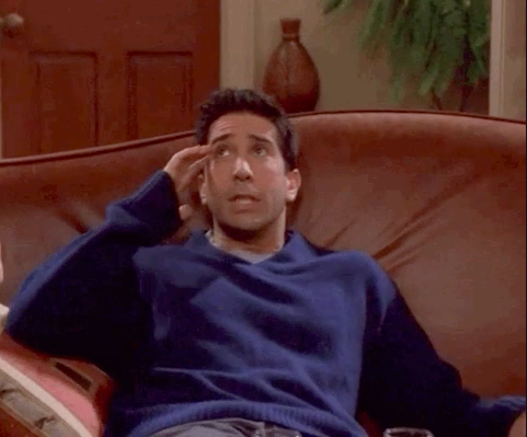Ross sitting on a couch looking flustered and holding his temple on &quot;Friends&quot;