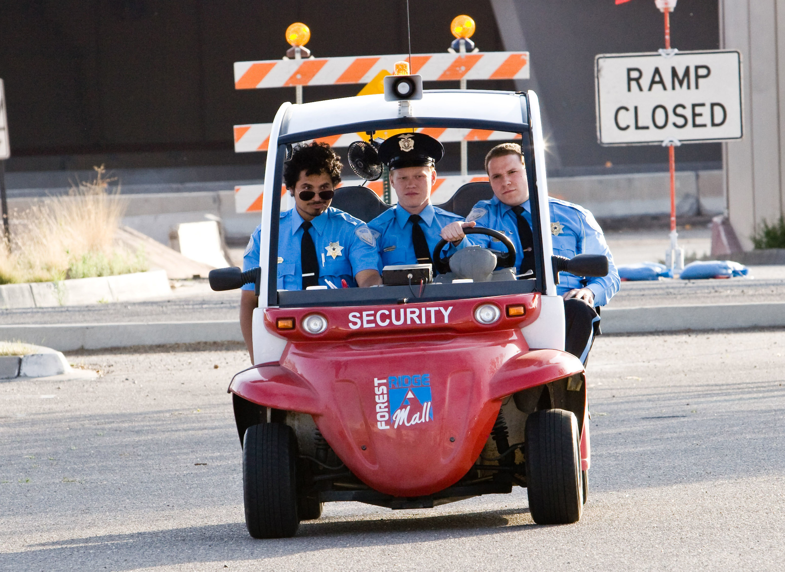 Michael Pena, Jesse Plemons, and Seth Rogen riding in a security cart.