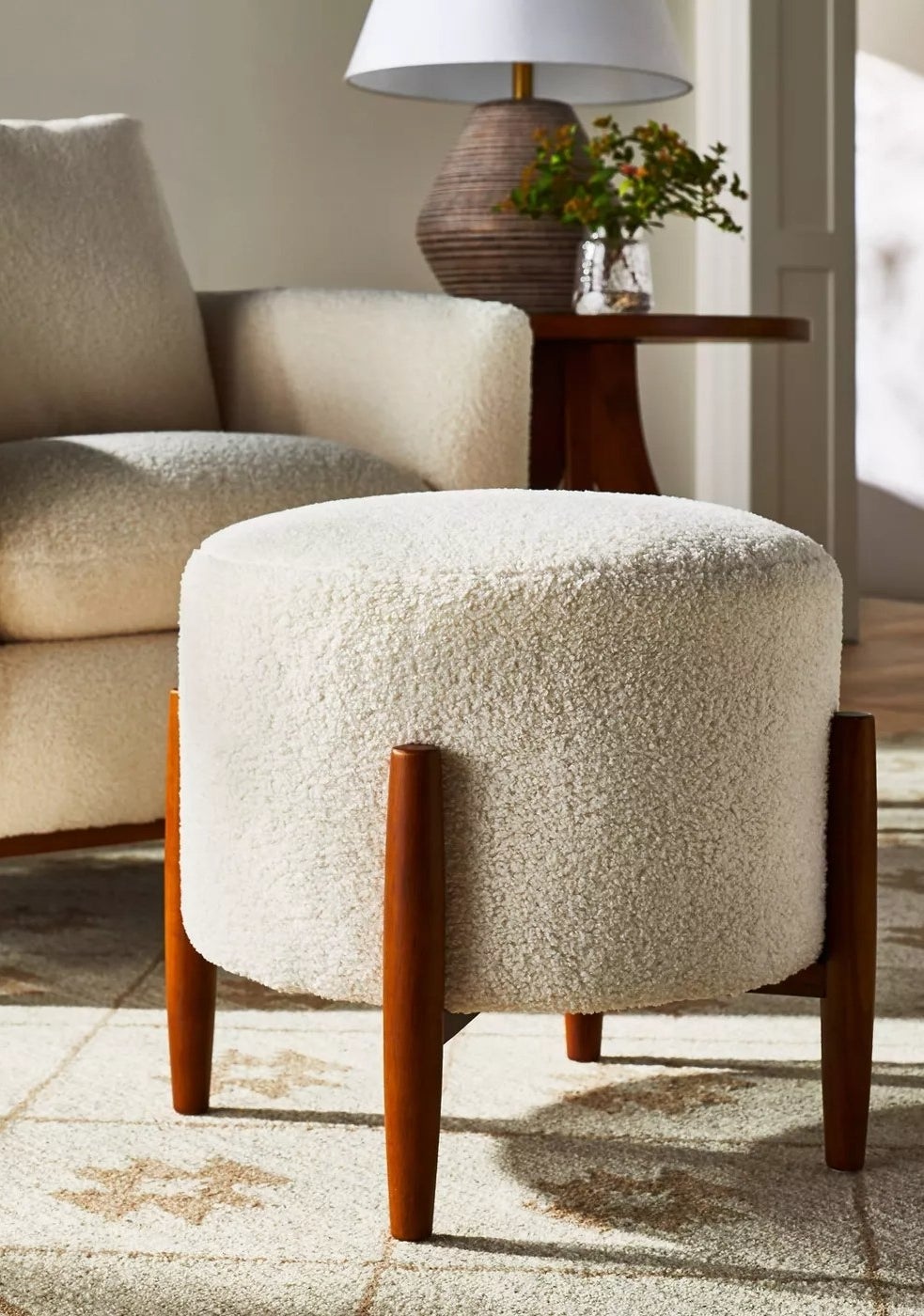 The ottoman with brown wood legs