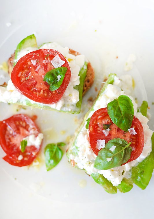 Toast topped with cottage cheese, avocado, tomato, and basil