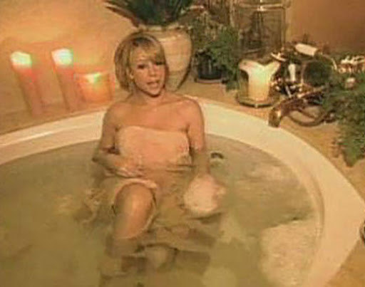 Mariah Carey wearing a towel sitting in a tub