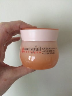 Reviewer's photo showing them holding the jar of collagen cream