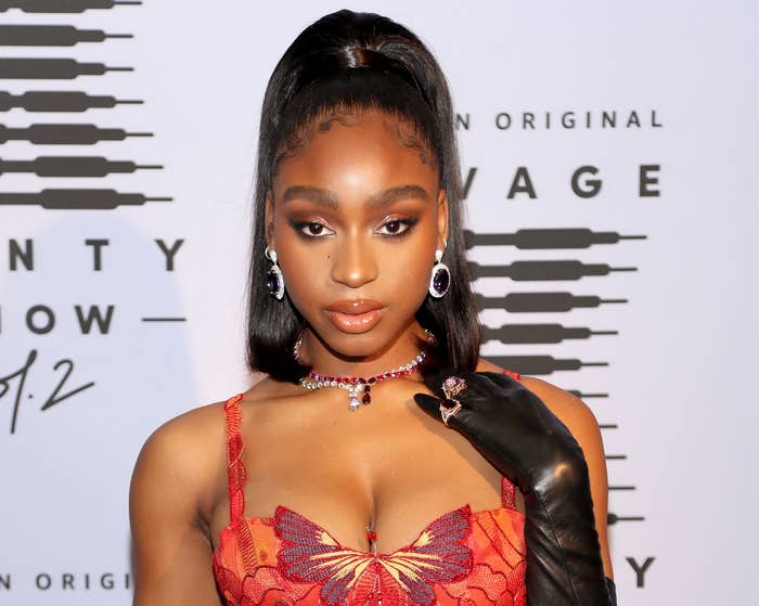 Normani wears a red tank top with an embroidered butterfly at the bust
