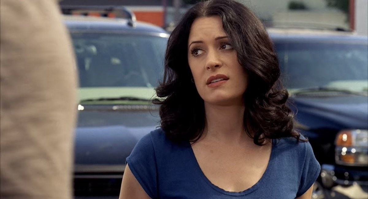 Emily Prentiss with curly hair wearing a scoop neck t-shirt