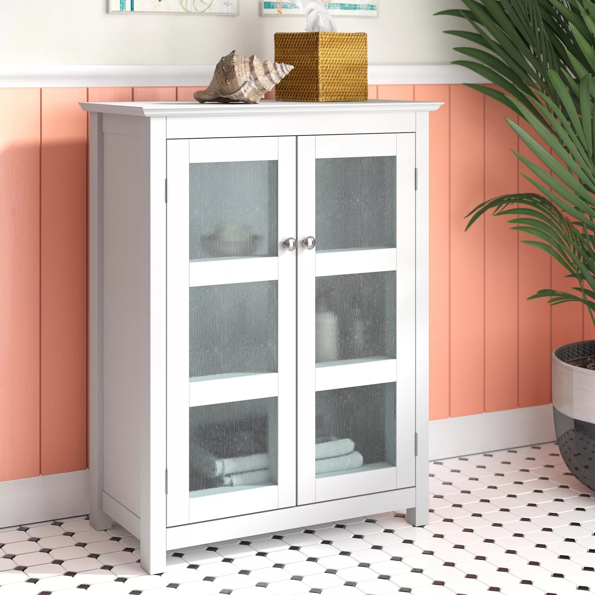 A free-standing bathroom cabinet with a seashell and tissues on top