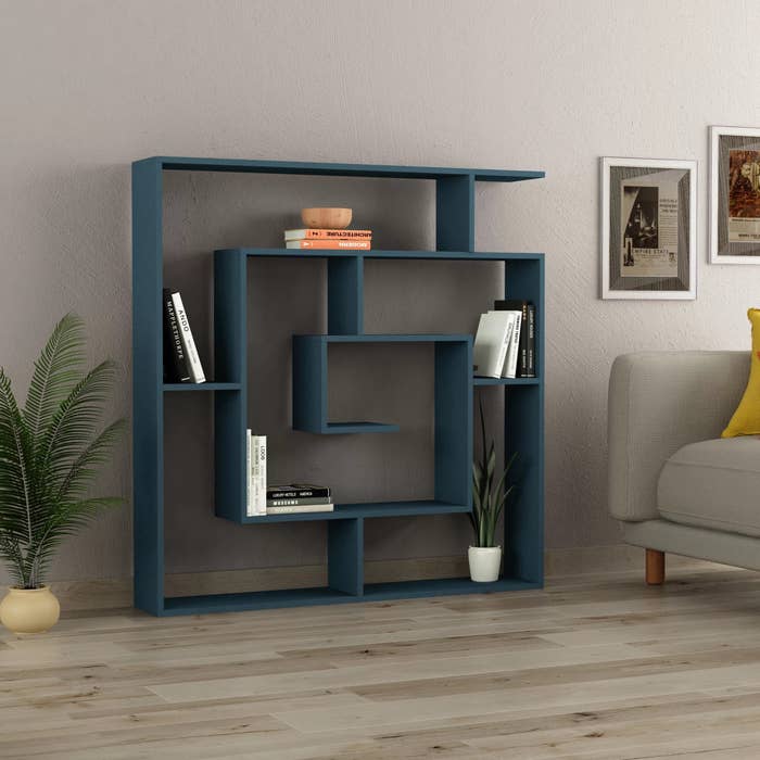 A turquoise bookcase holding books and a plant