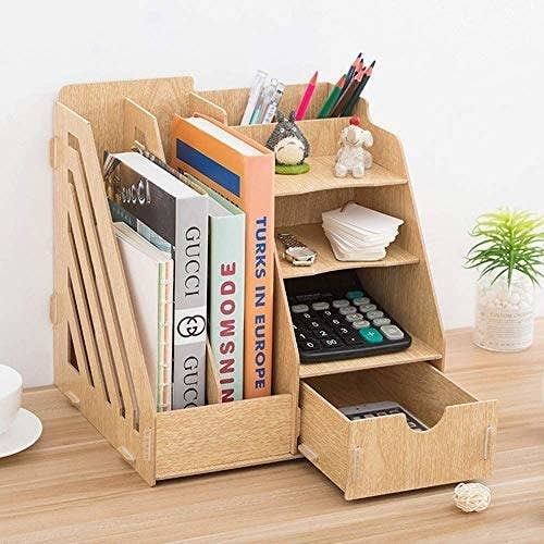 A desk organiser with books, calculator, tags and a watch in it