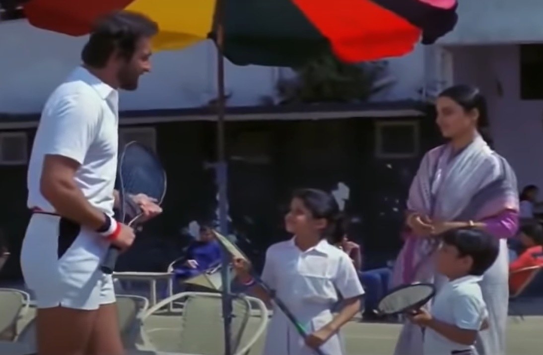 Sanjay speaks to aarti&#x27;s children while holding a racquet and clad in booty shorts and bonds