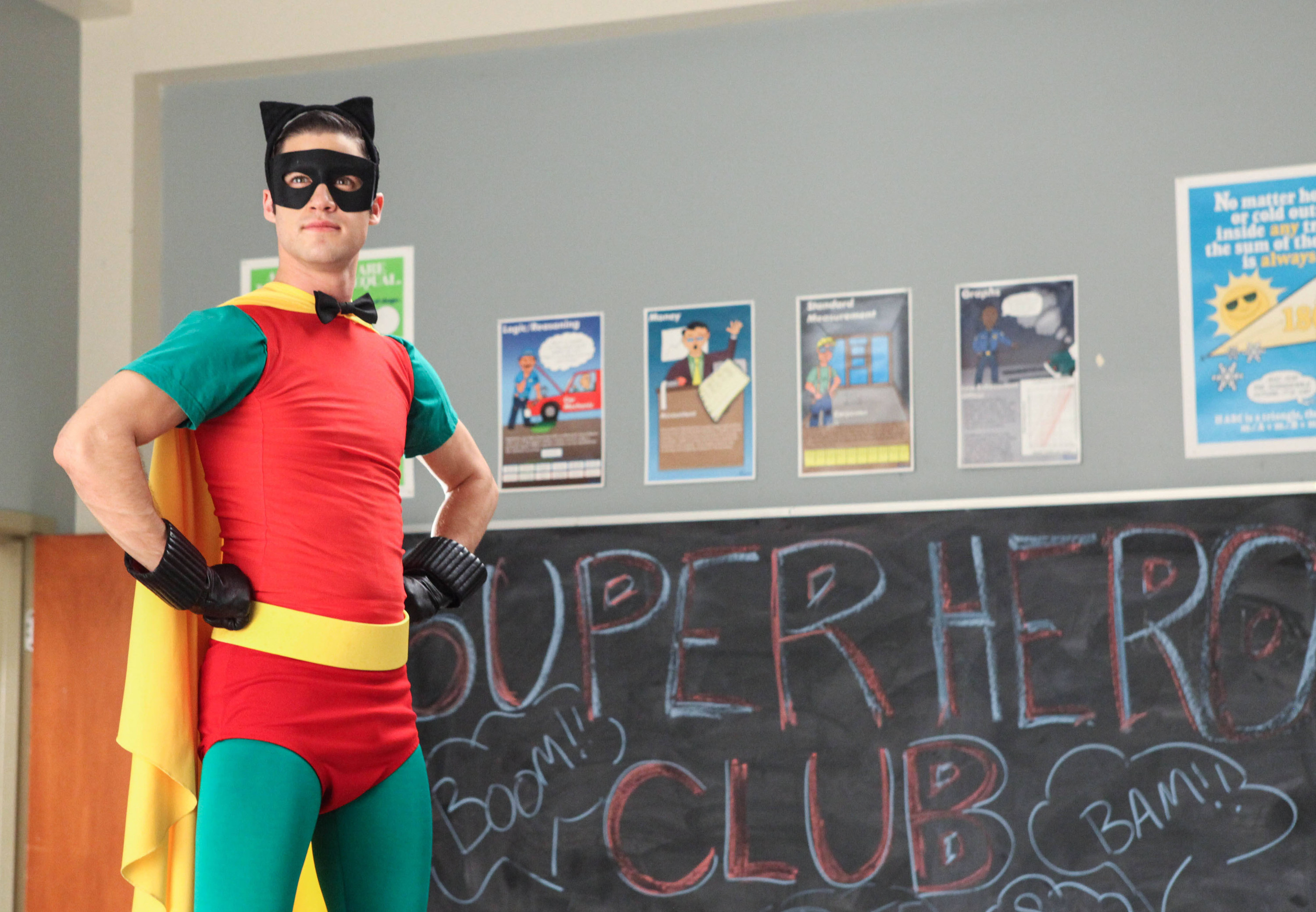 Criss dressed up as Robin in front of a chalkboard that says &quot;Superhero Club&quot; on it