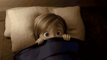 a gif of riley from inside out looking nervous in bed