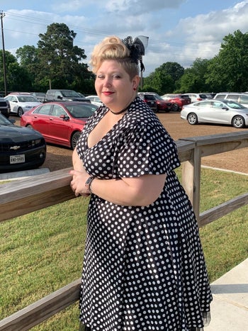 reviewer wearing the dress in black with white polka dots