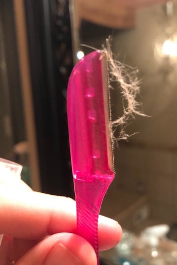 a reviewer photo of the razor with shaved peach fuzz attached 