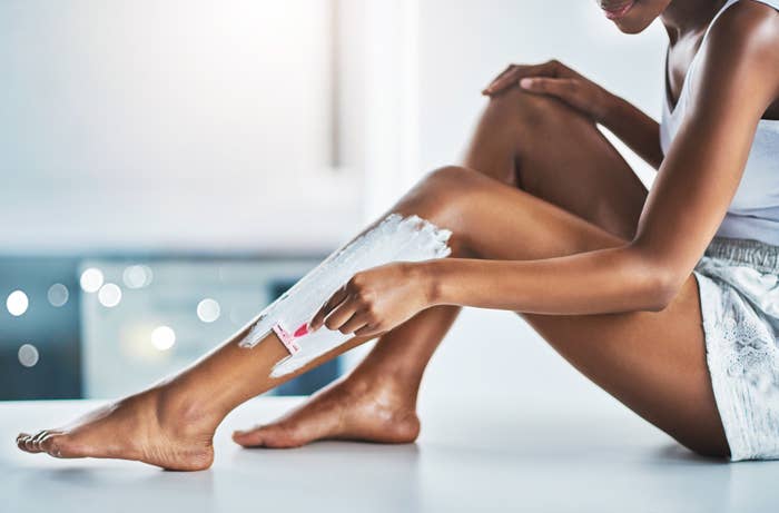 A woman shaves her legs