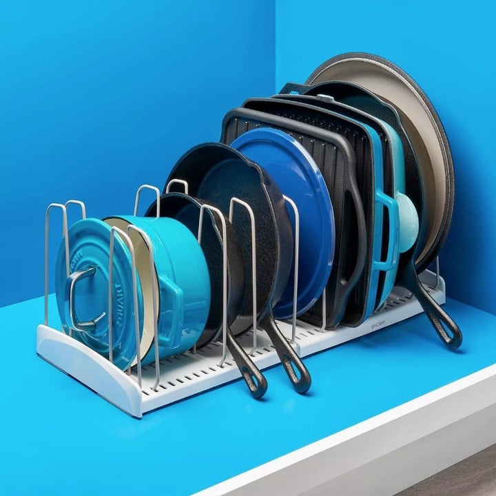The cookware rack with blue and black pots and pans
