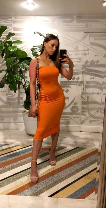 Reviewer wearing orange dress