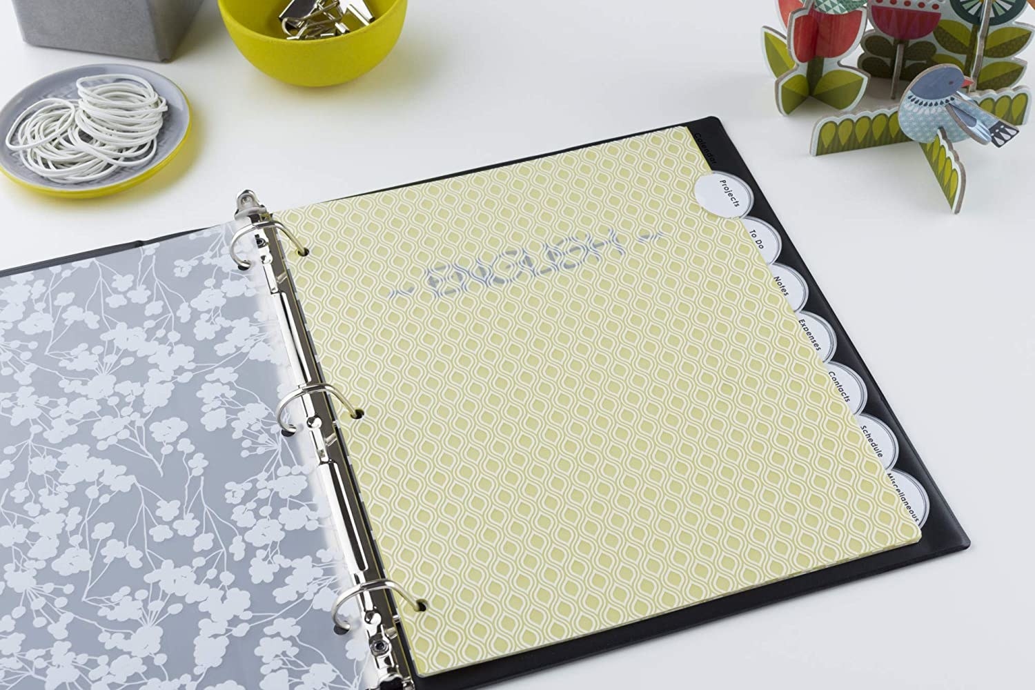 An open binder with the translucent floral print dividers inside