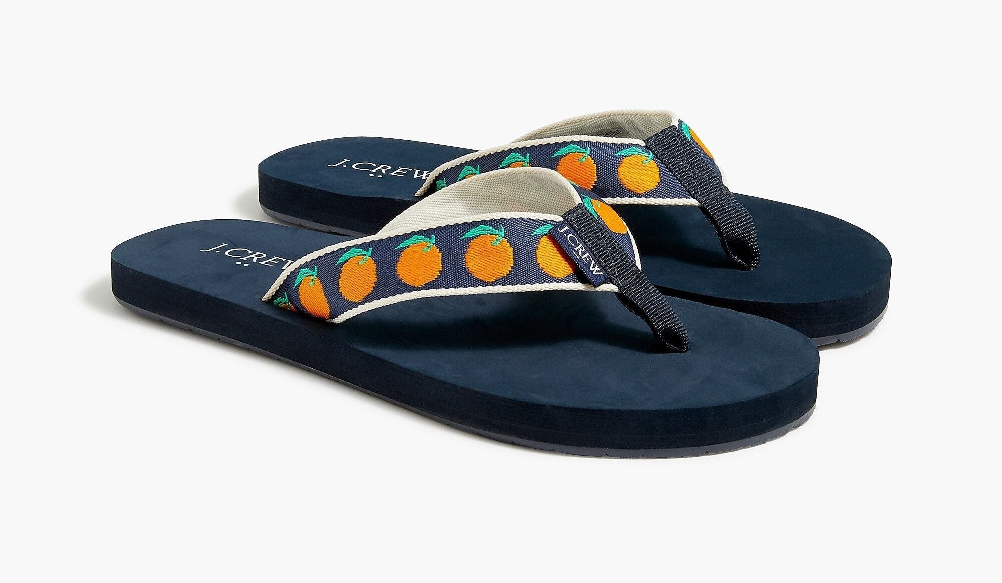 The pair of navy embroidered orange flip-flops