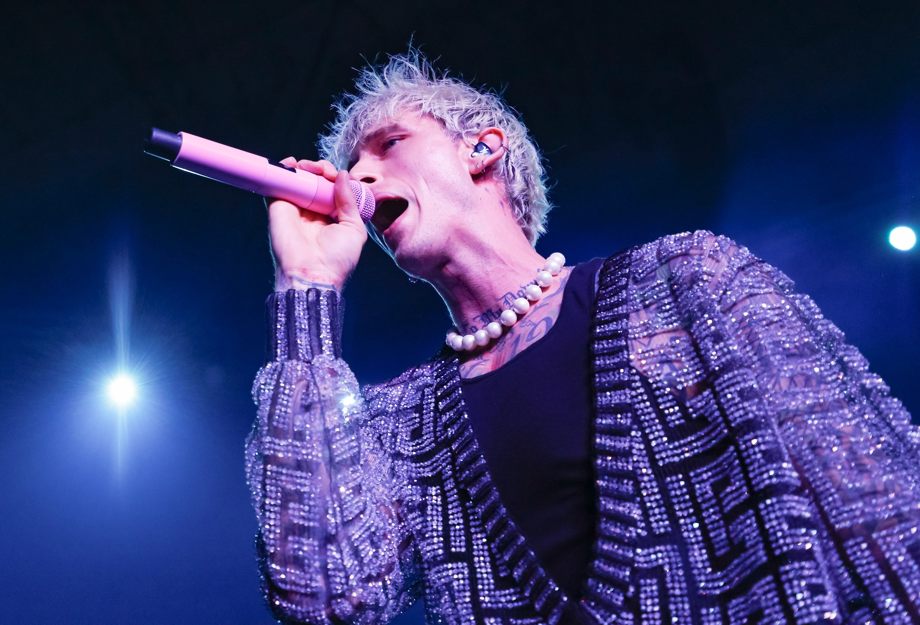 Machine Gun Kelly is photographed singing into a microphone onstage