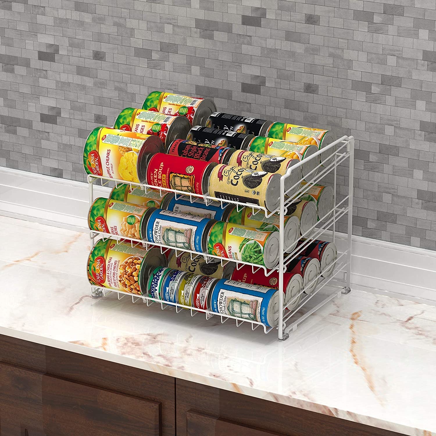 A three-tiered can rack on a kitchen counter, laden with canned goods