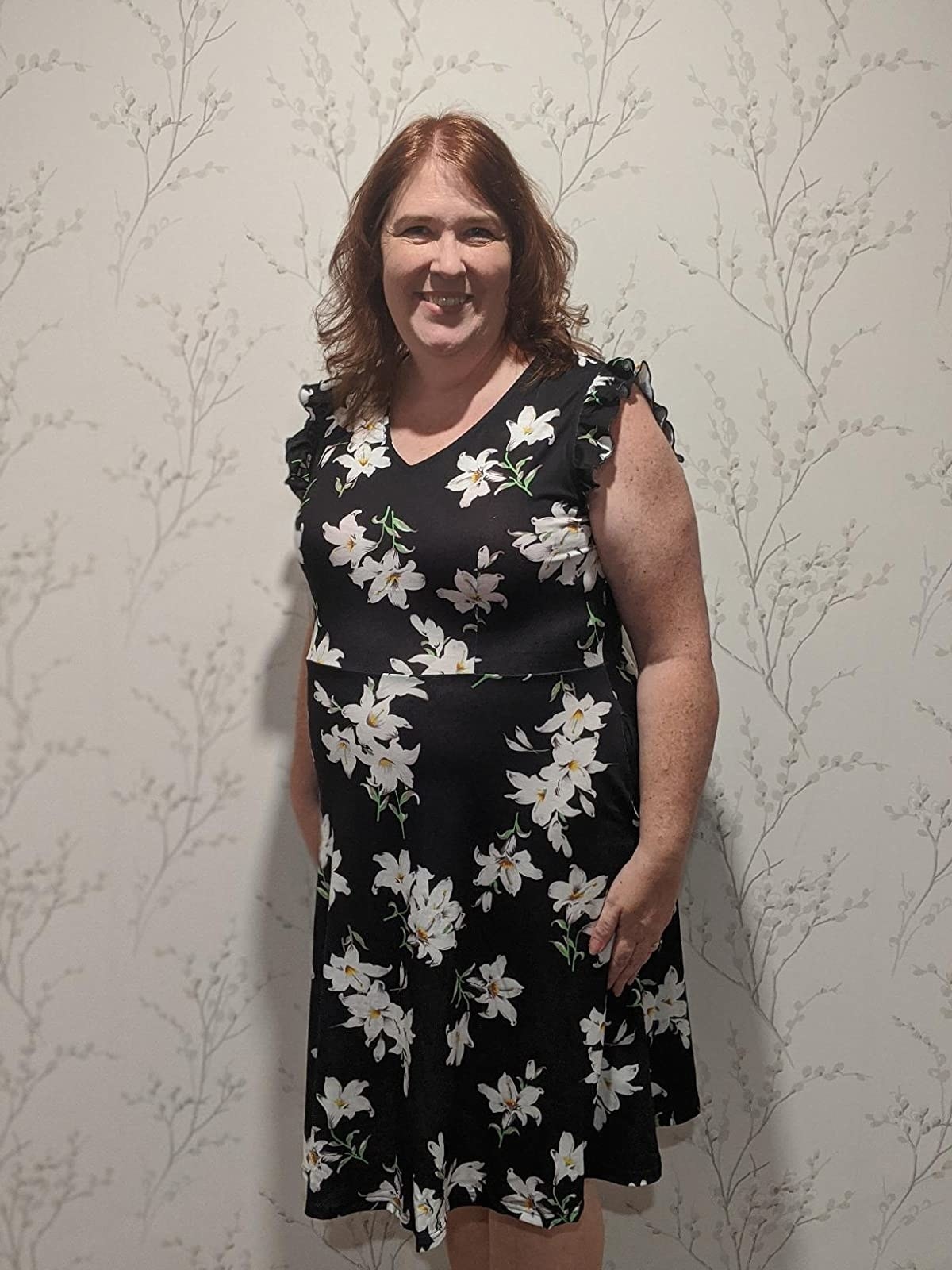 Reviewer wearing black and white floral dress