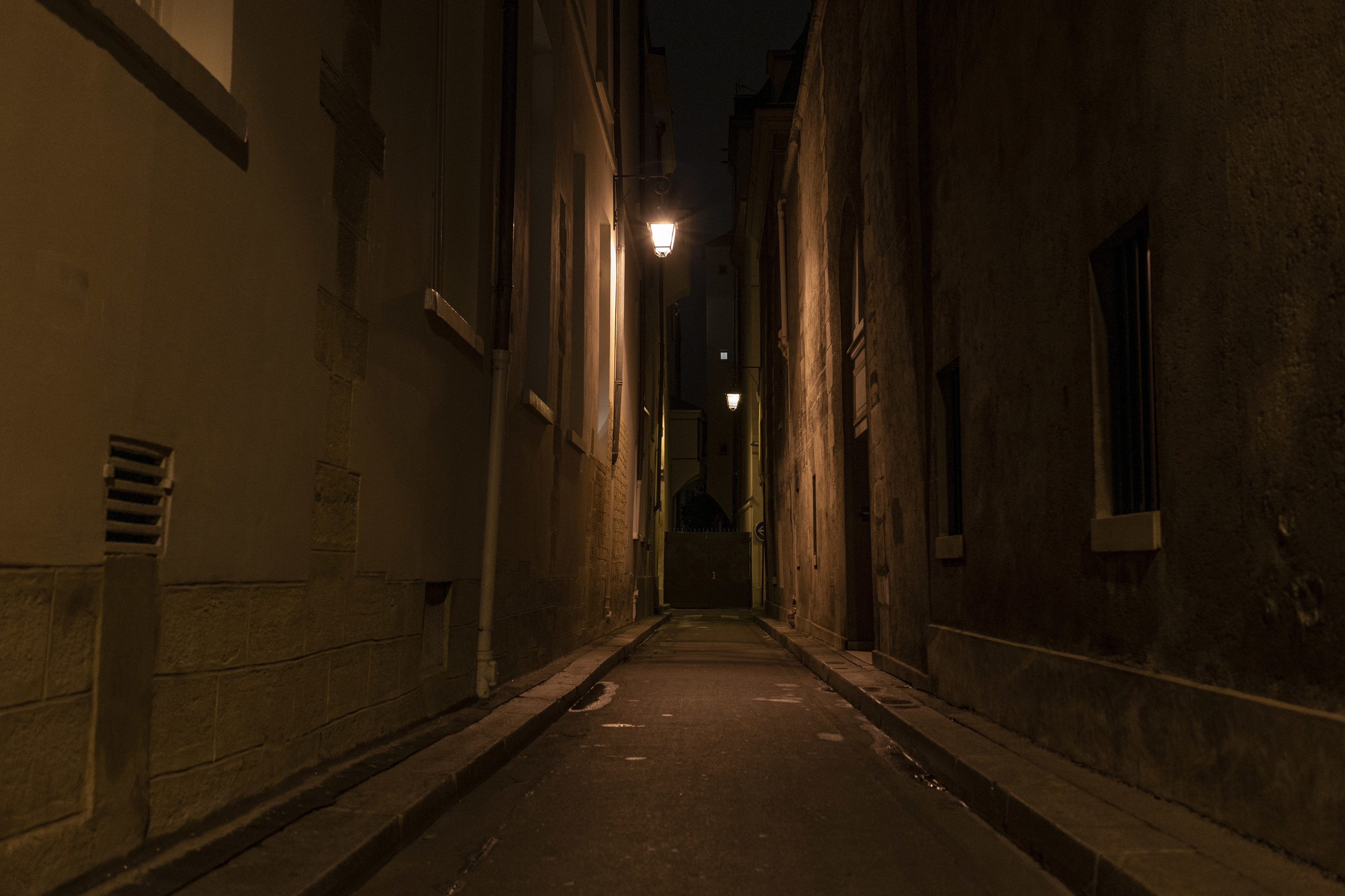 A dark alley at night with only dim lighting