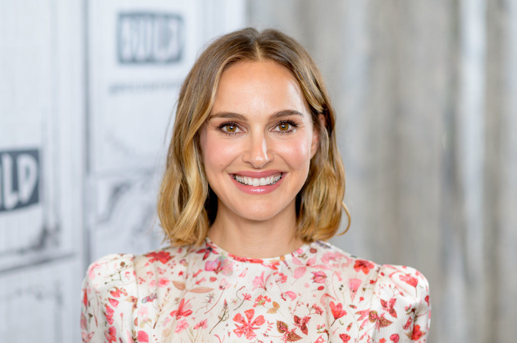 Natalie smiling at the camera, wearing a floral outfit