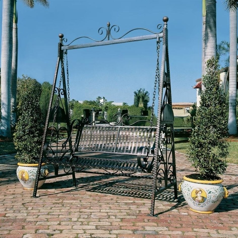 traditional iron garden swing with curved designs in the a-frame and a swinging chair in the center