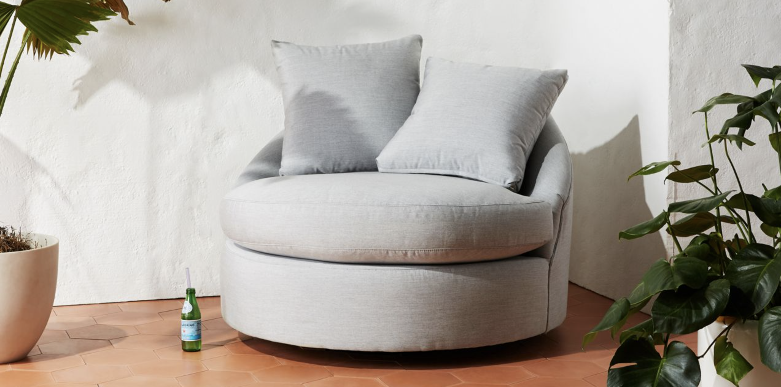 rounded plush chair with two pillows