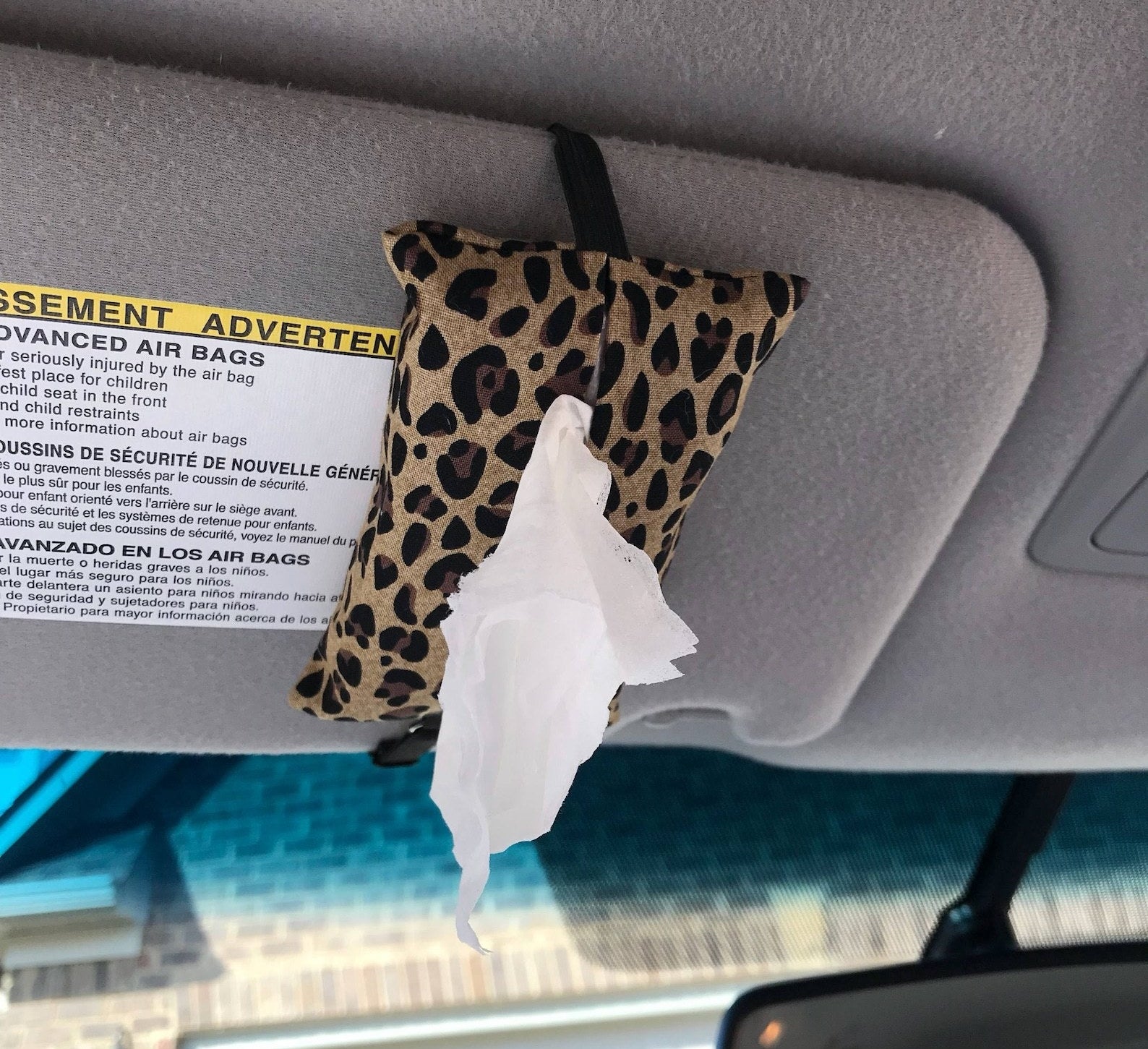 A leopard print car visor tissue holder