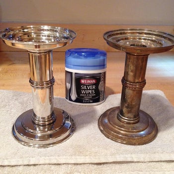one tarnished candle holder and one shiny clean next to a tub of the wipes