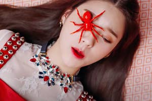 HeeJin with a fake spider covering one of her eyes in the "Vivid" music video