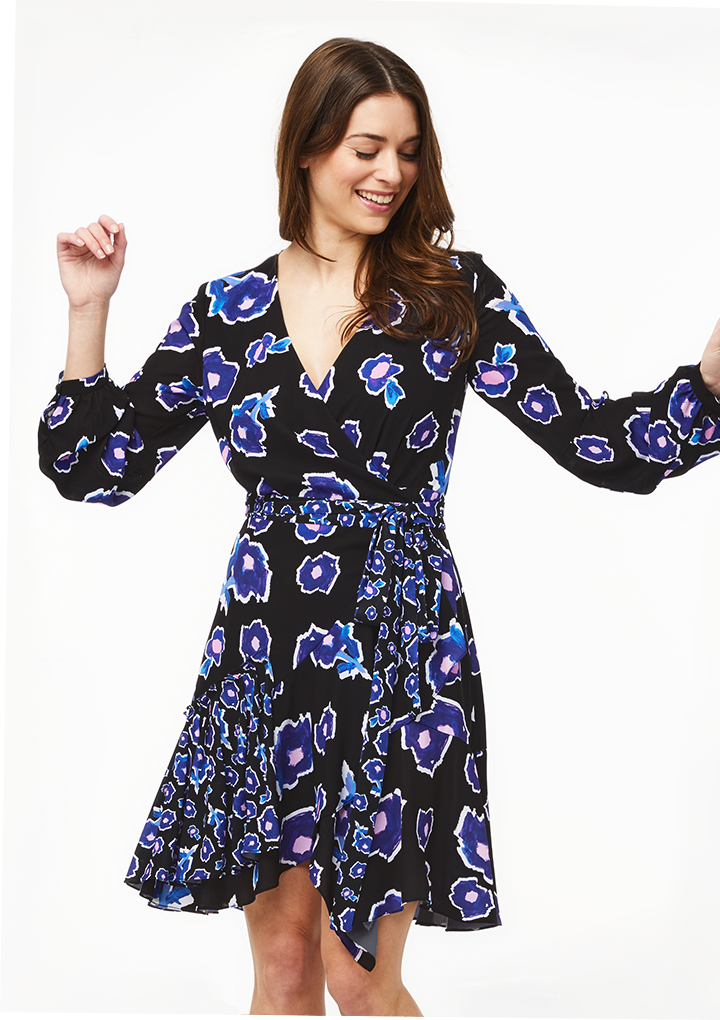 model wearing the black wrap-style dress with blue and white flowers all over it