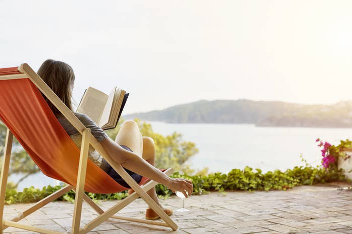 A woman sitting in a chair reading by herself.