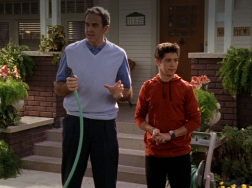 Craig Anton holds a hose next to Ricky Ullman in their front yard
