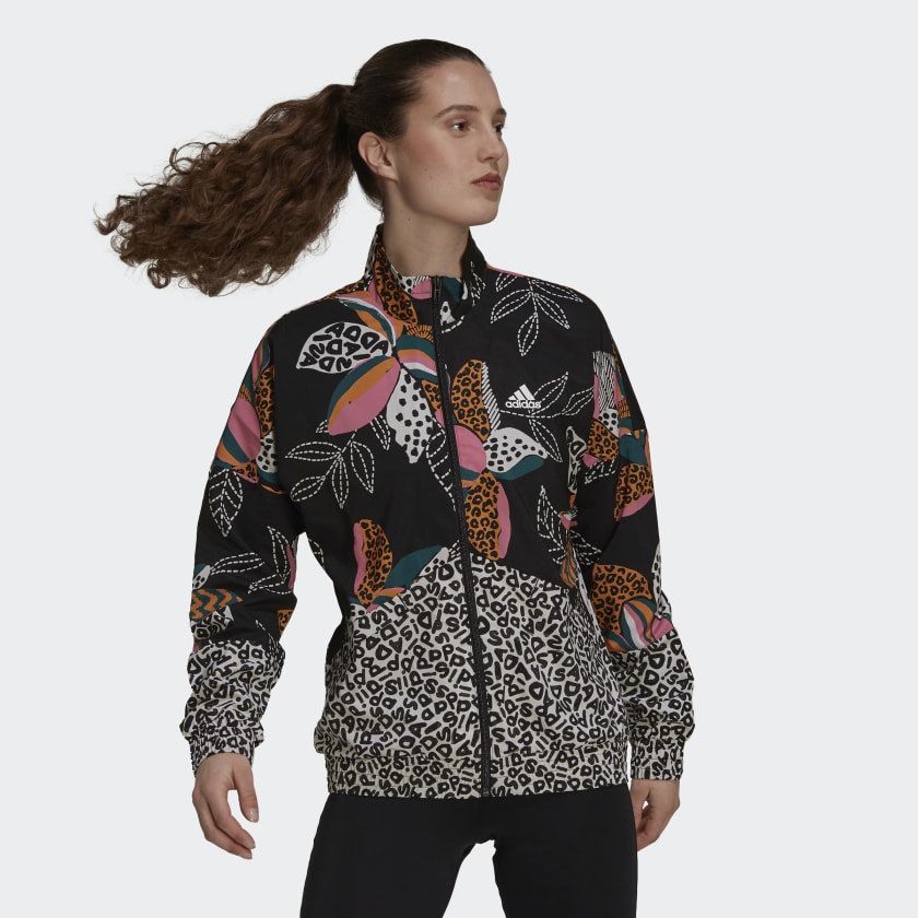 a person wearing a funky patterned adidas windbreaker