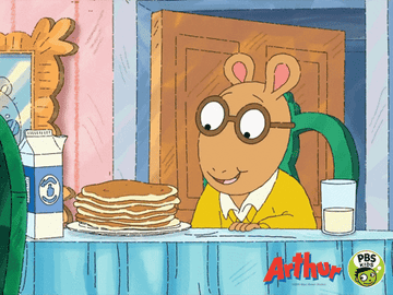 Arthur taking a big bite of pancakes