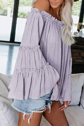 a model wearing the top in light purple showing the tiered bell sleeve 