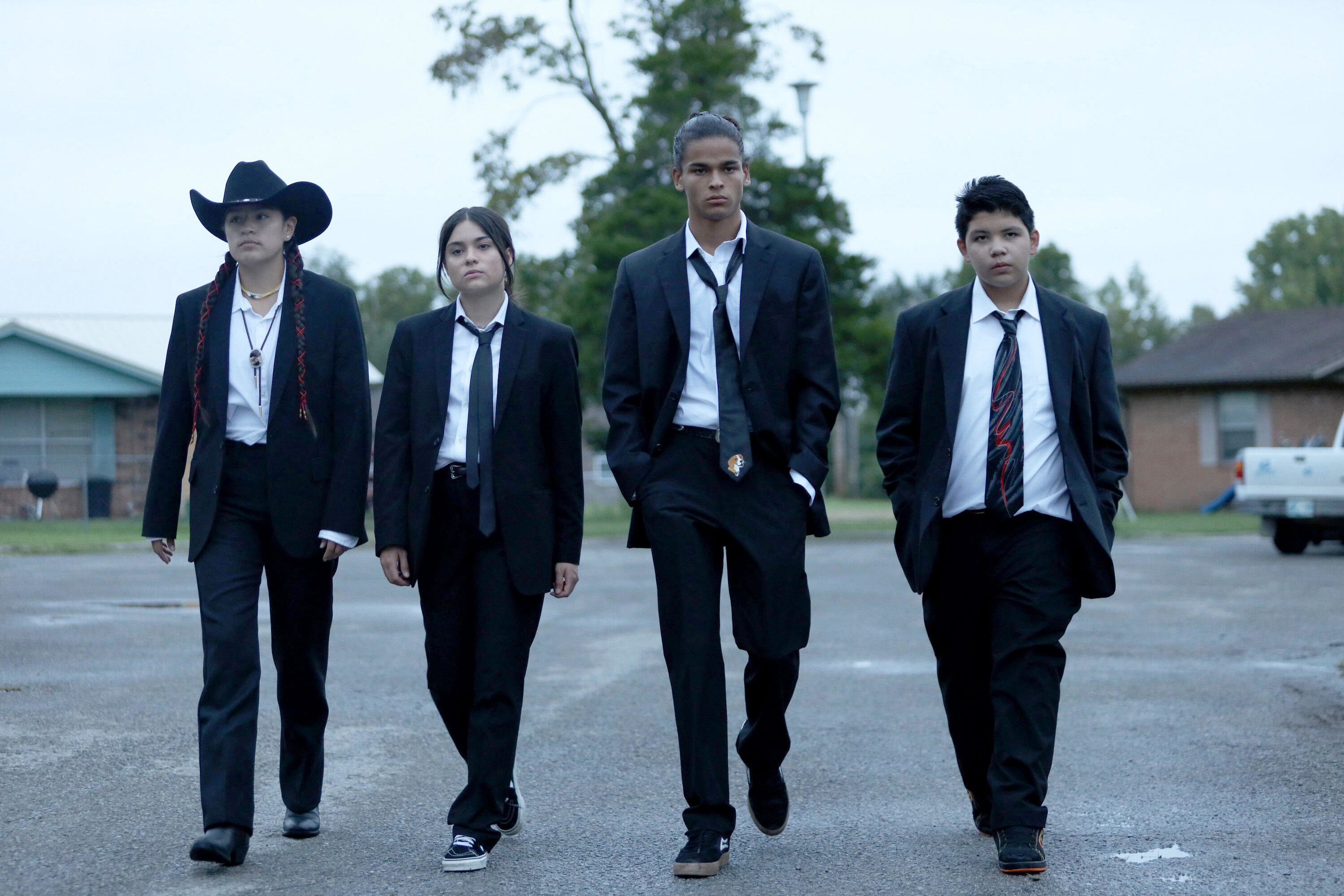 Four teens wearing suits and walking together