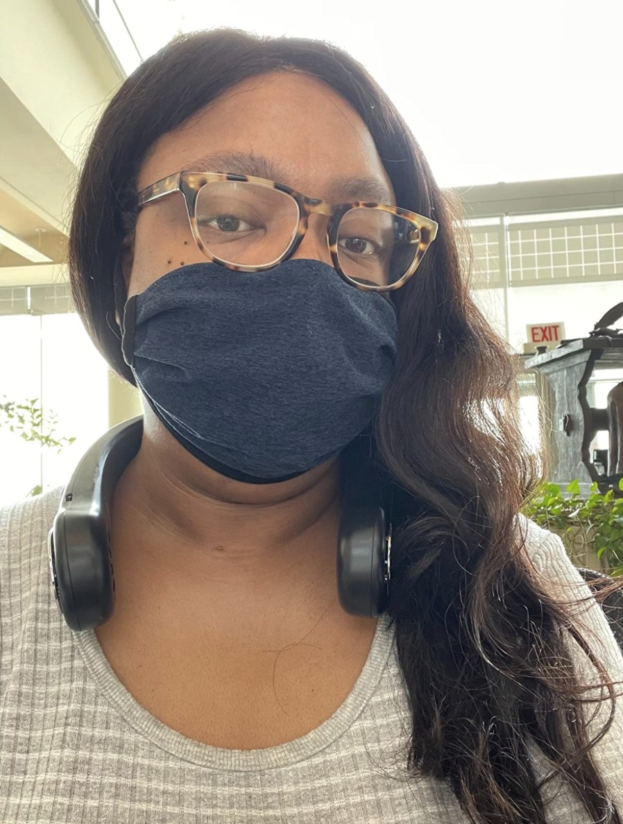 reviewer using the neck fan in black