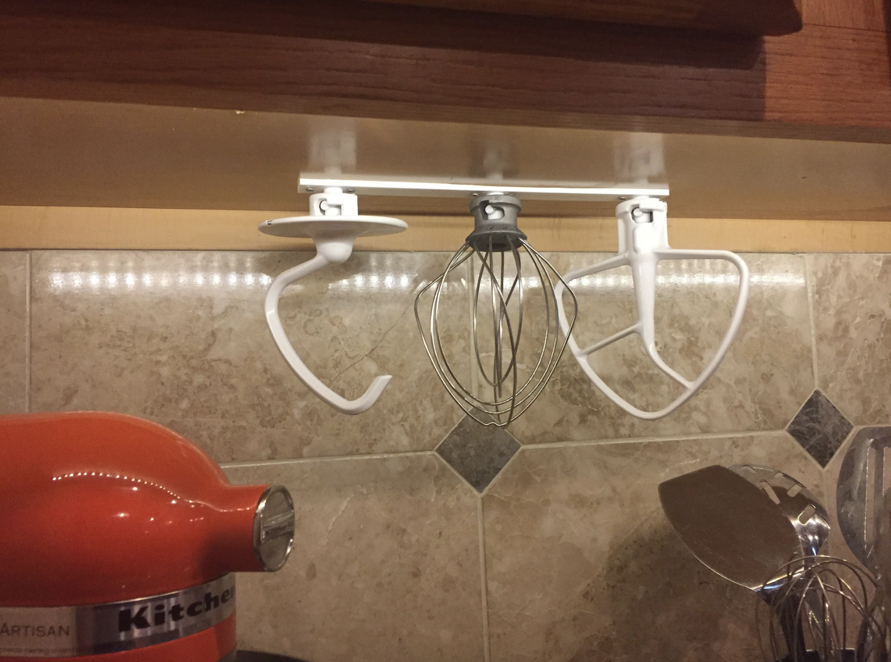 the mixer organizer attached to the underside of a kitchen cabinet