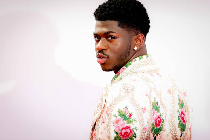 Lil&#x27; Nas looking over his shoulder in an embroidered floral print jacket