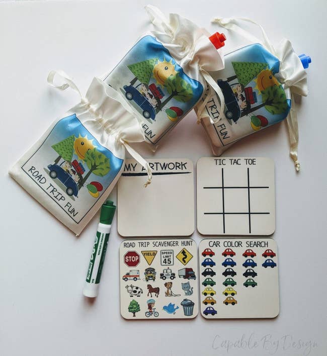 Four square boards with different games, a marker, and pouches