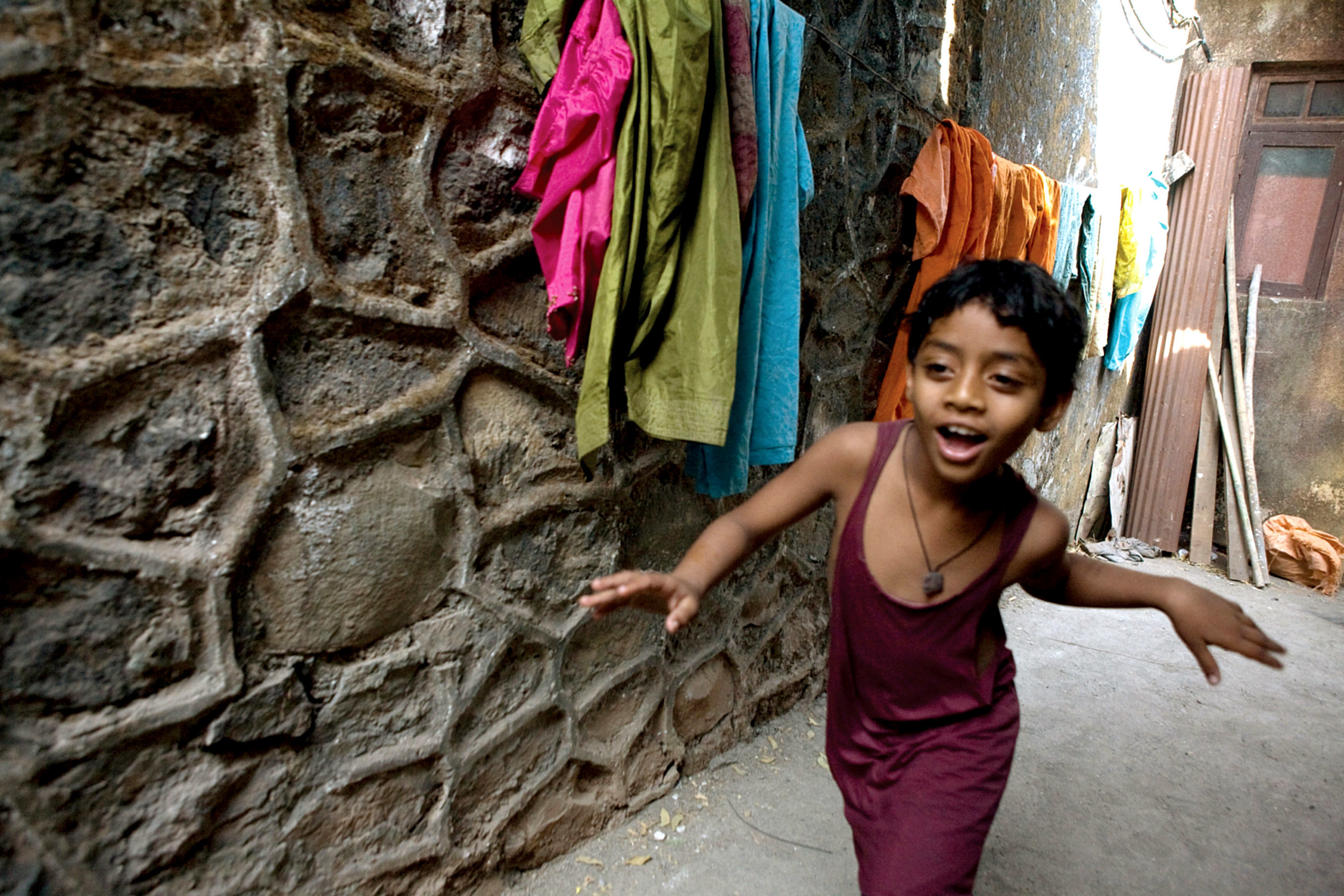 young Salim dances past colorful laundry