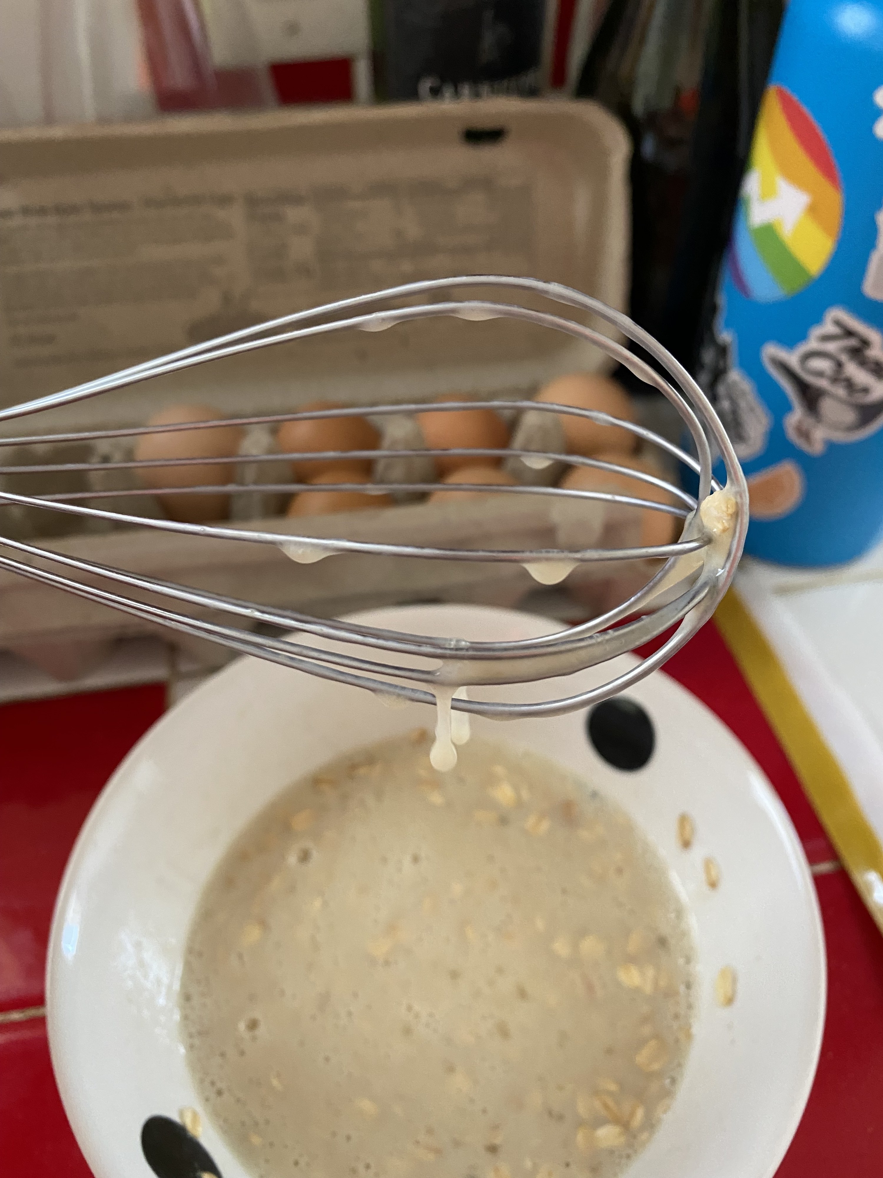 A closeup of the batter on a whisk, basically just a bunch of watery drips